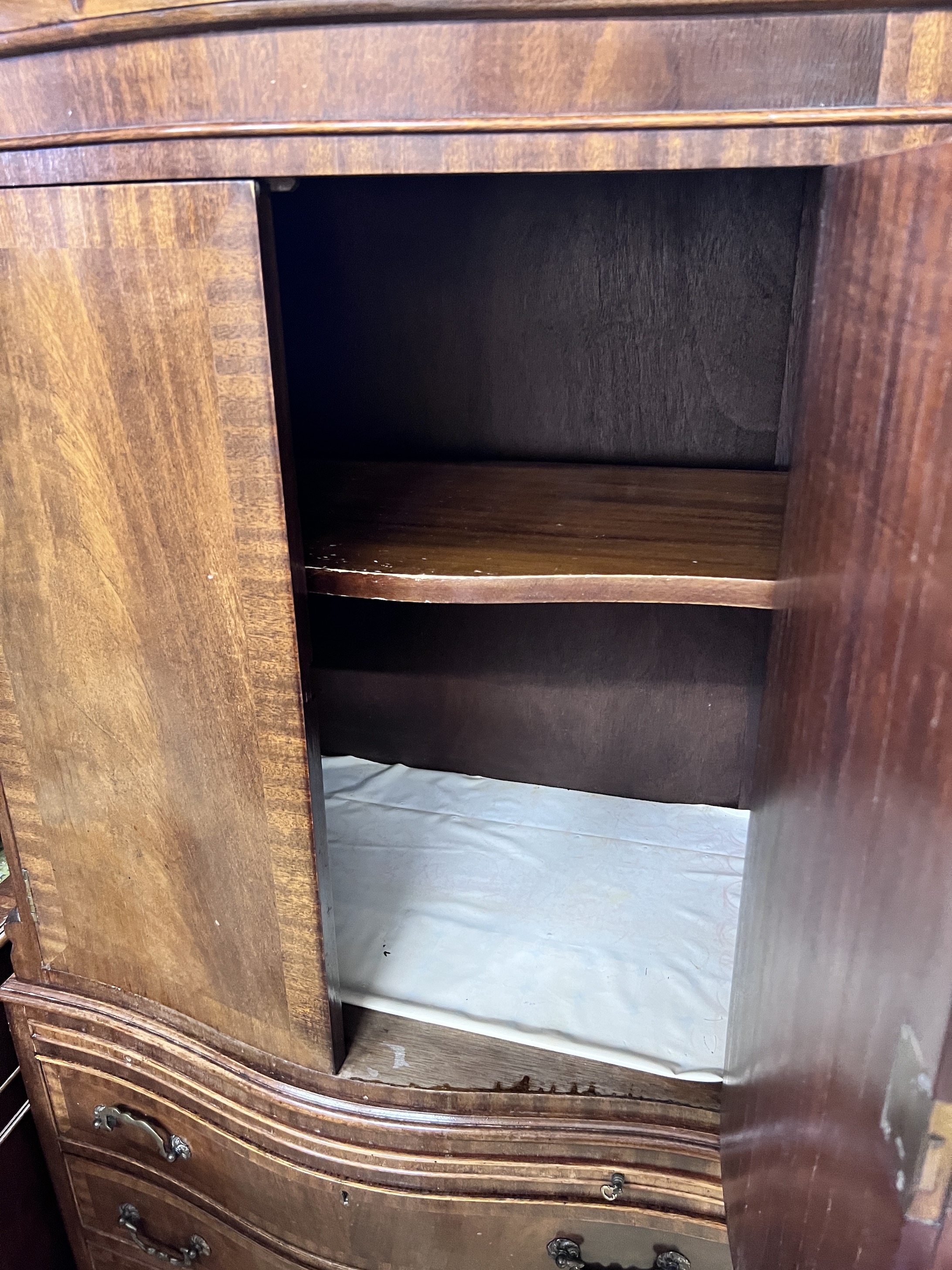 A mahogany serpentine cocktail cabinet fitted with four drawer base, width 73cm